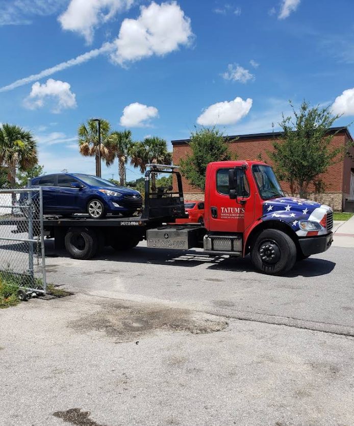 Sedan loaded onto a flatbed tow truck outside D's Auto Repair